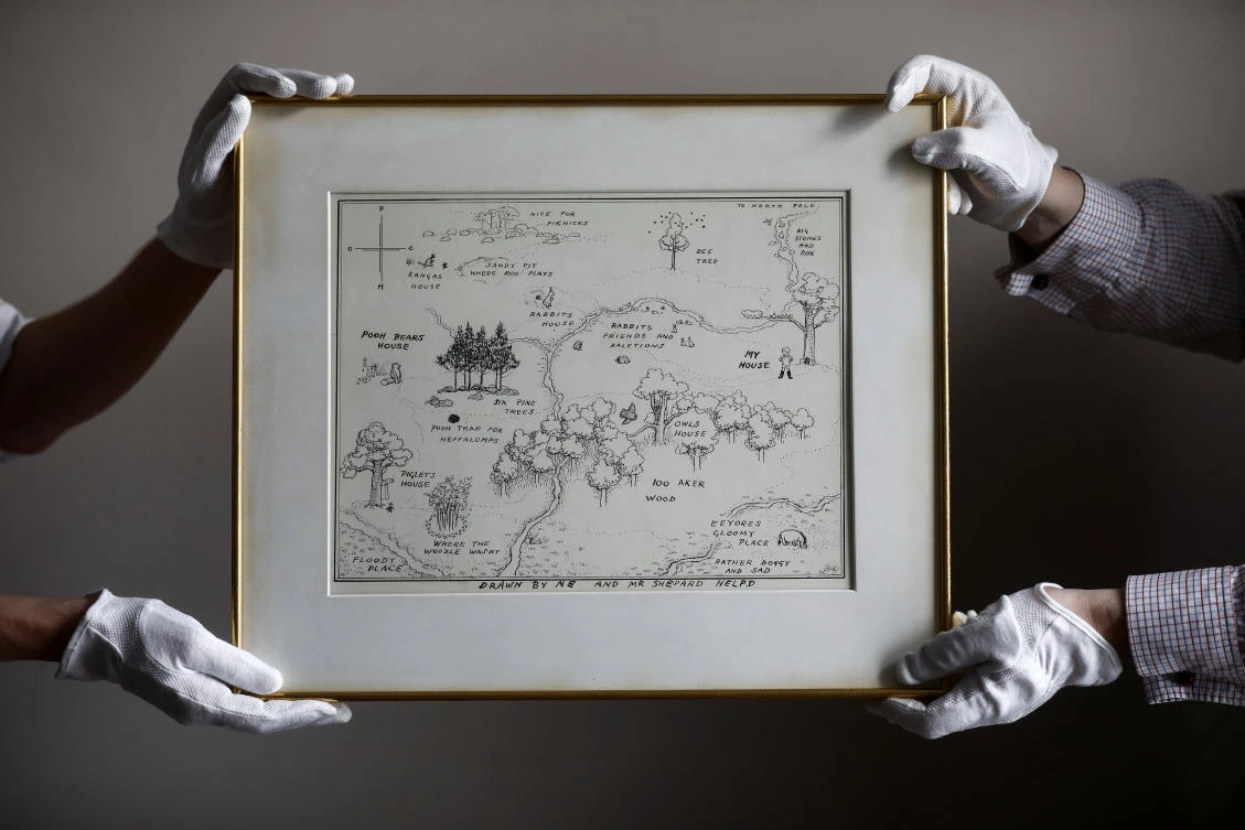 Sotheby’s staff hold the original map of Winnie the Pooh’s Hundred Acre Wood by E.H. Shepard at Sotheby’s auction rooms in London, Britain, May 31, 2018. (Reuters)