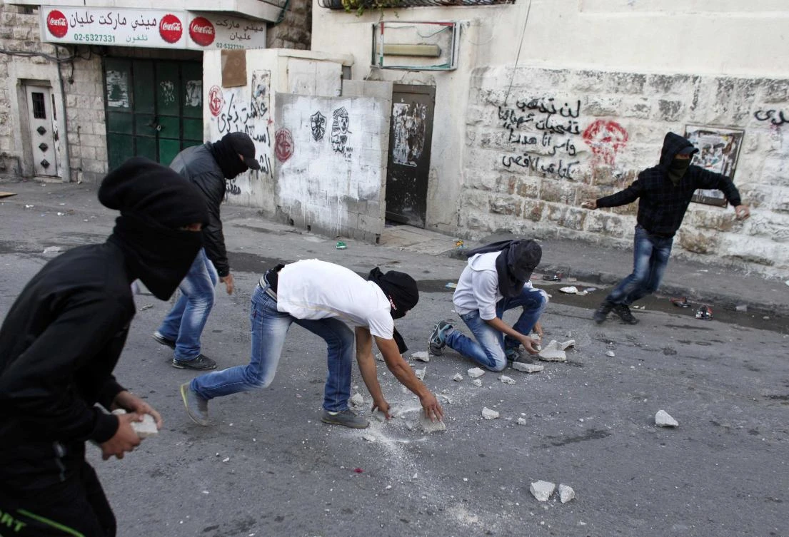 Palestinians throw stones at Israeli security forces (unseen) during clashes in protest to Israel's military operation in Gaza. (REUTERS)