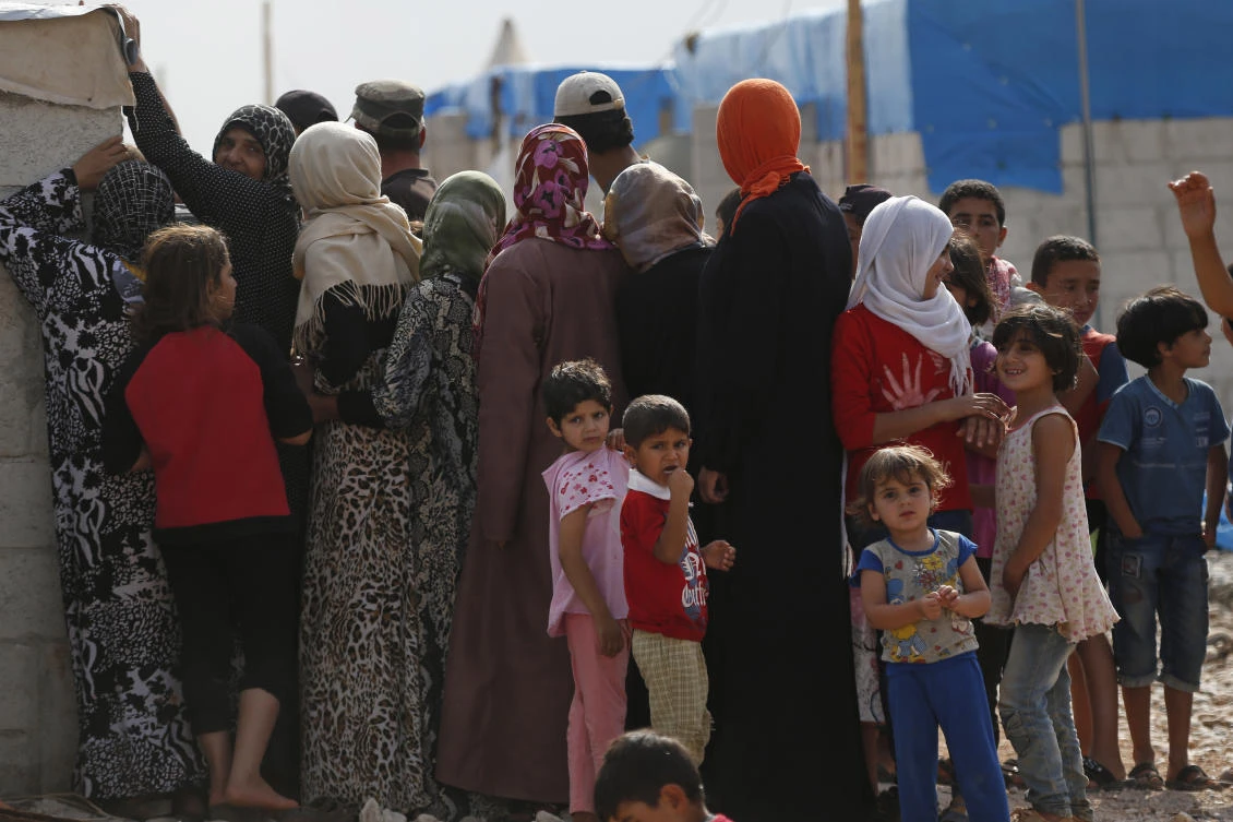 Syrians wait for food handouts at a camp for internally displaced people on the outskirts of Jarablus, northern Syria, Wednesday, May 30, 2018. (AP)