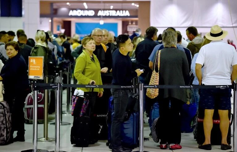 Passengers queue to check in at the international terminal in Sydney Airport. Two decades after airports in Sydney, Melbourne, Brisbane and Perth were sold to pension funds and infrastructure investors, they are reporting the highest margins in the world. (AFP)