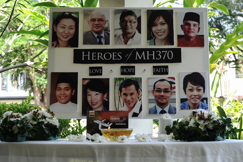 A poster showing cabin crew from missing Malaysia Airlines flight MH370 is displayed during a prayer at a school in Petaling Jaya on March 8, 2016. (AFP)