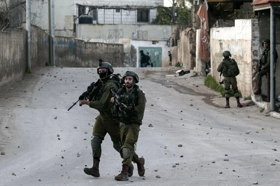 Israeli soldiers advance through the Palestinian village of Burqin in the northern occupied West Bank, during an army search operation on February 3, 2018. (AFP)