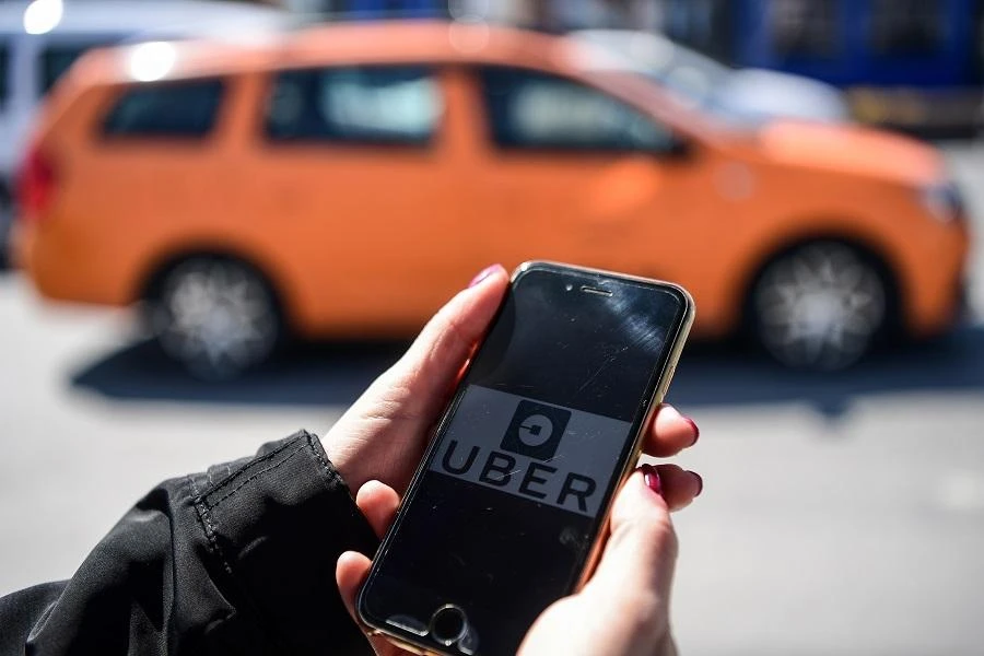 A woman opens the UBER application on her mobile phone at the Eminonu district on March 30, 2018 in Istanbul. (AFP)
