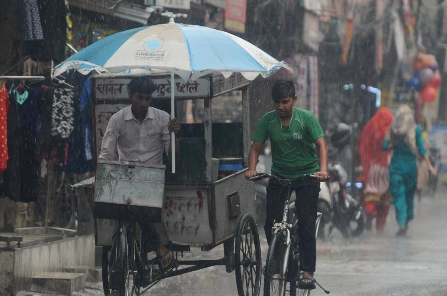 Indian commuters make their way under the rain in Amritsar on May 12, 2018. (afp)