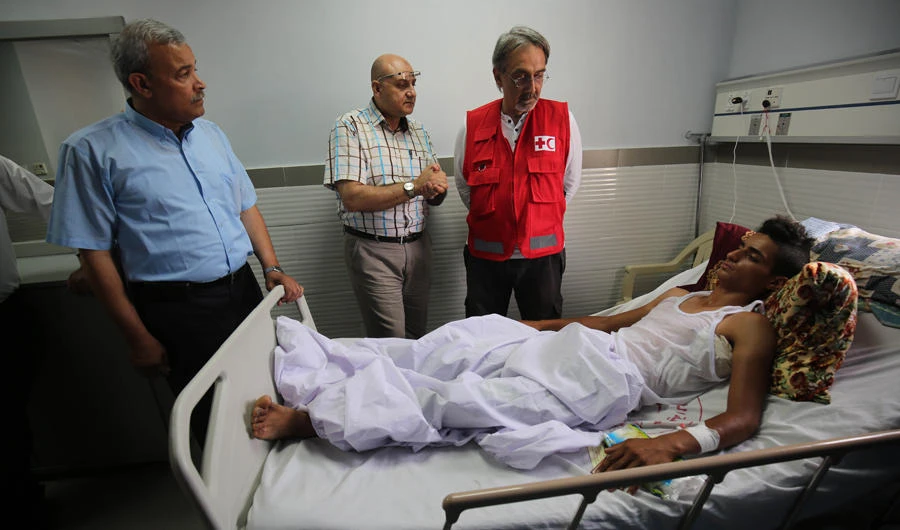 Francesco Rocca (R), the President of the International Federation of Red Cross and Red Crescent Societies, meets a Palestinian, receiving treatment for wounds sustained during protests at the Gaza-Israel boder, during his tour of the Red Crescent Hospital in Khan Yunis in the southern Gaza Strip, on May 22, 2018. (AFP / SAID KHATIB)