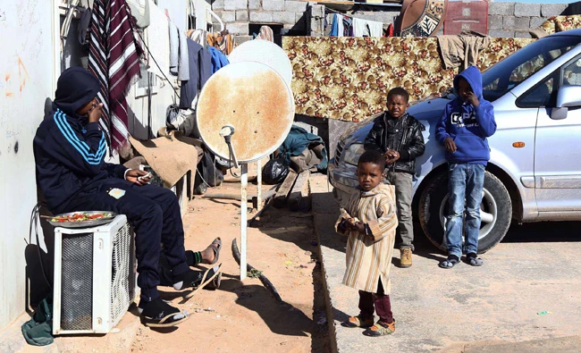 Young Libyans gather outside a makeshift house on January 4, 2015 in the capital Tripoli, at a refugee camp that hosts internally displaced people from the town of Tawargha, south of Mistrata. (AFP)