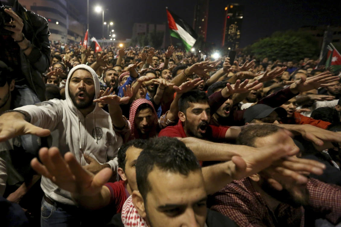 Jordanians march toward the office of outgoing Prime Minister Hani Mulki early Tuesday to demand the scrapping of proposed tax increases. (AP)