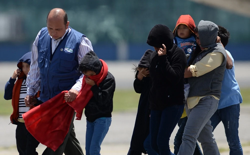 Part of a group of thirteen children, aged between one and 13, and seven mothers walk upon arrival in Guatemala deported from the United States amidst the humanitarian crisis caused by Central American immigrant children, at the Air Force Base in Guatemala City on July 22, 2014. (AFP)