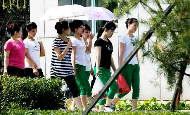 In this Sept. 2, 2017, photo, North Korean workers walk into the Hong Chao Zhi Yi garment factory after visiting a street market in the city of Hunchun in northeastern China's Jilin province. (AP)