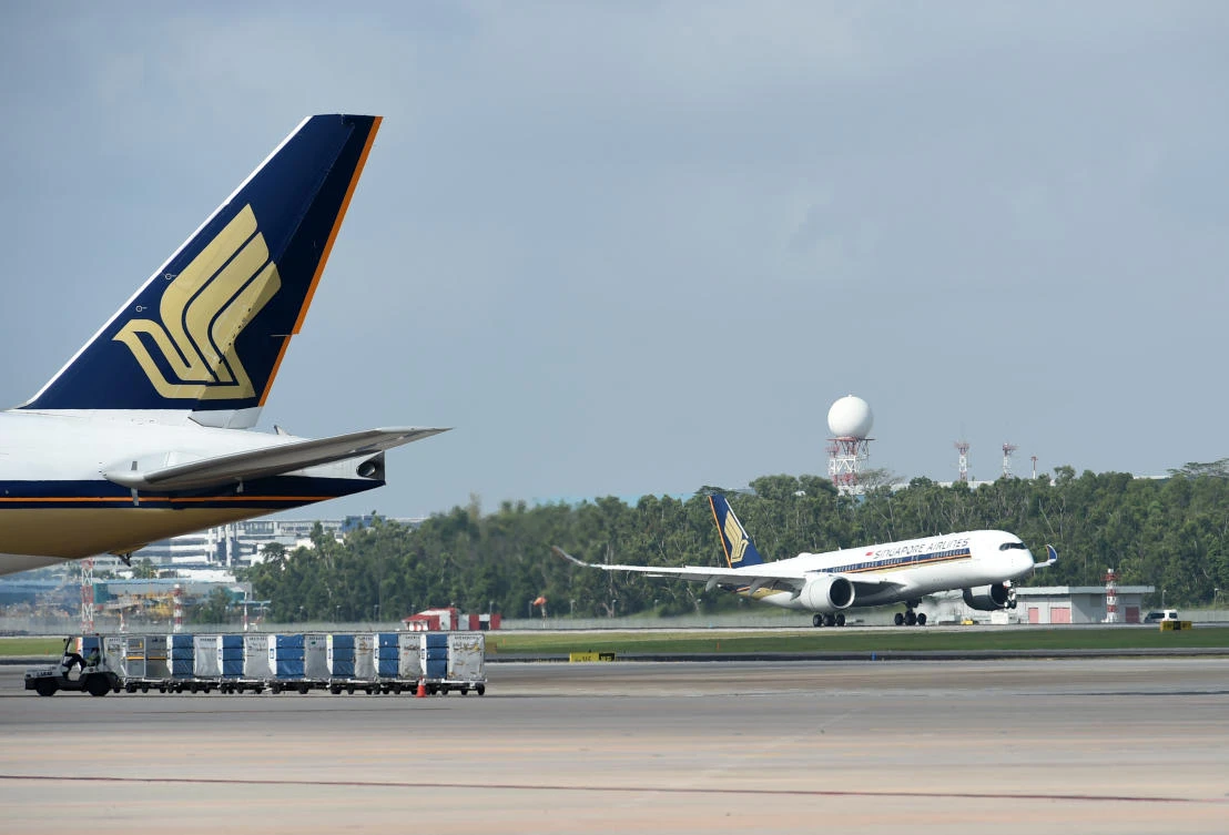 In this file photo taken on March 3, 2016 a Singapore Airlines Airbus A350-900 (R) lands at Singapore International Changi airport. (AFP)