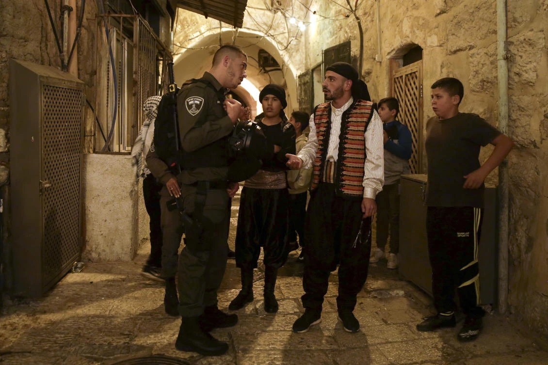 In this Tuesday, June 5, 2018 photo, traditionally dressed Palestinian public wakers, known as musaharati, are stopped by the Israeli border police in the Jerusalem’s Old City. (AP)