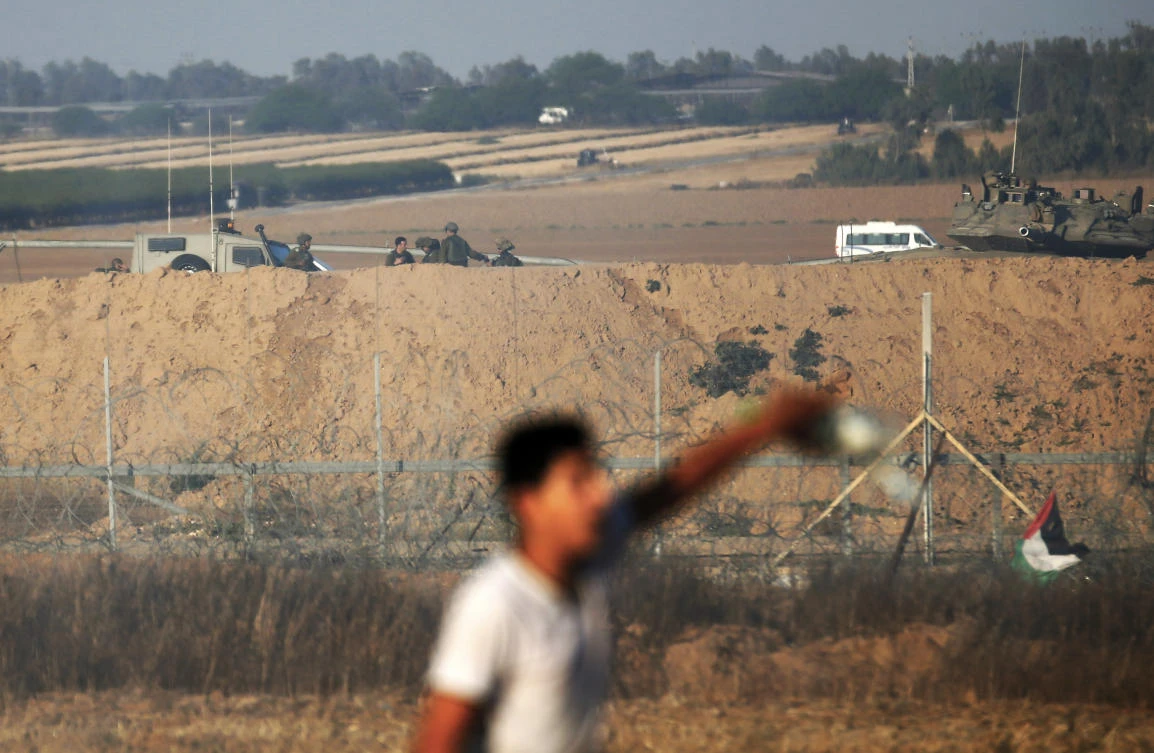 Israeli soldiers keep watch as a Palestinian gestures along the Gaza Strip-Israel border fence during a demonstration east of Khan Yunis in the southern Gaza. (AFP)