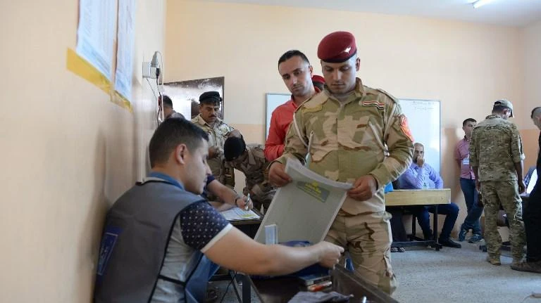 An election official checks documents as a member of the Iraqi security forces casts his vote during an early ballot for the parliamentary election in Mosul. Many of Iraq’s longtime political figures — seemingly irremovable since the dictator’s fall — were pushed out of their seats by new faces. (AFP)