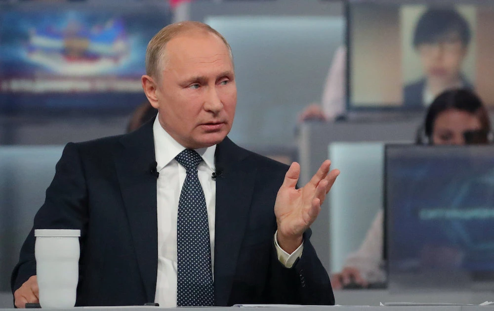 Journalists watch a live broadcast of a nationwide call-in attended by Russian President Vladimir Putin, in Moscow, on June 7, 2018 in which he said Russia is not currently planning to withdraw all of its troops from Syria, and sees the military operation there as a "unique opportunity." (AFP)