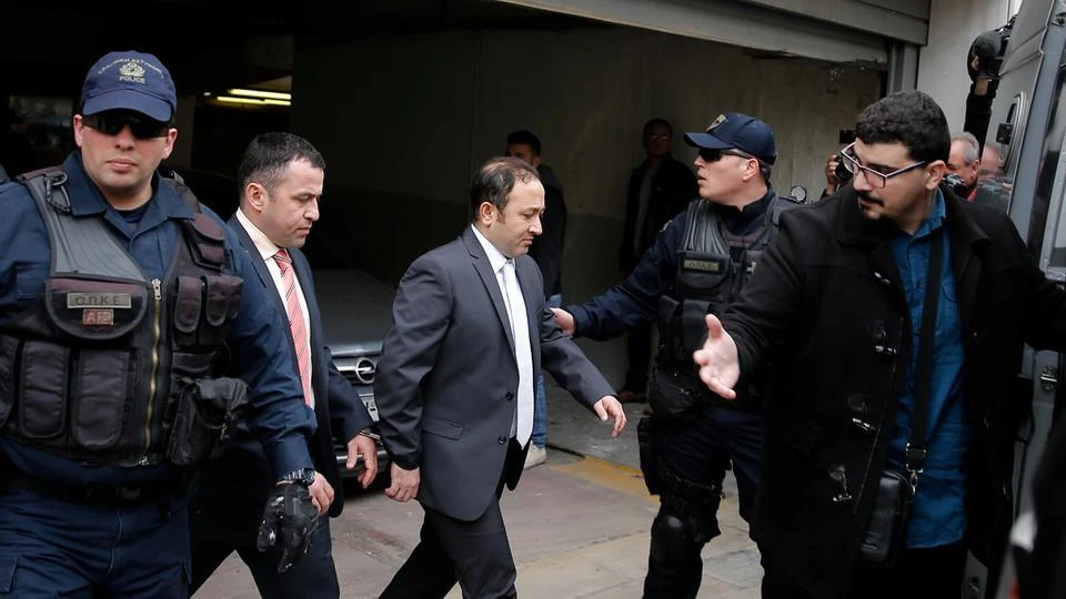 Two of the eight Turkish soldiers, who fled to Greece in a helicopter and requested political asylum after a failed military coup against the government, are escorted by police officers as they leave the appeals court in Athens. (Reuters)