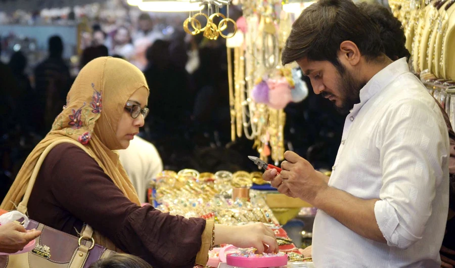 A woman selects jewelry for Eid at a local market in Karachi. (AN photo by Khurshid Ahmed)