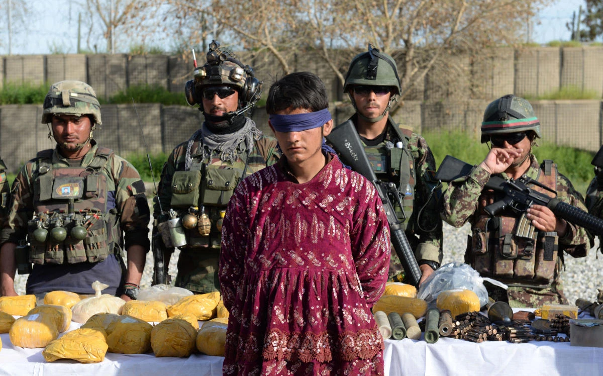 Security personnel present a Taliban fighter dressed as a woman, arrested during an operation in the Bati kot District of Nangarhar province, to the media on March 17, 2018. Afghan President Ashraf Ghani announced for the first time an unconditional ceasefire with the Taliban coinciding with Eid. (AFP)