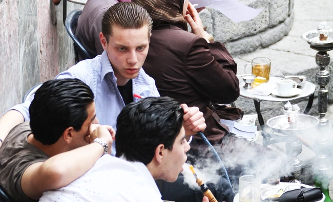 Young Syrian men smoke 'nargileh' or waterpipes, which are popular among locals and tourists, at a traditional cafe in Damascus' Old City. AFP