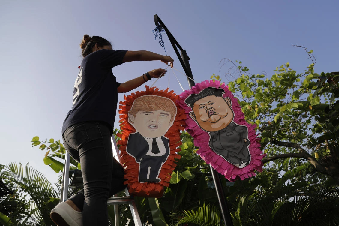 A staff member of a local Mexican restaurant displays pinatas with the caricatures of U.S. President Donald Trump and North Korean leader Kim Jong Un, ahead of the their upcoming summit, Thursday, June 7, 2018, in Singapore. (AP)