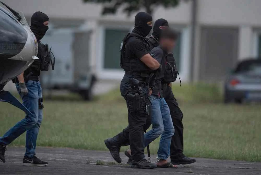 Police officers of a special unit escort Iraqi asylum seeker Ali Bashar, who is suspected of having killed a German teenage girl, from a helicopter to the police headquarters in Wiesbaden, western Germany, after he was flown back from Irbil to Germany on June 9, 2018. The 20-year-old man was brought back to Germany after admitting raping and murdering 14-year-old Susanna Maria Feldman, Iraqi Kurdish officials and German media reports said. (AFP)