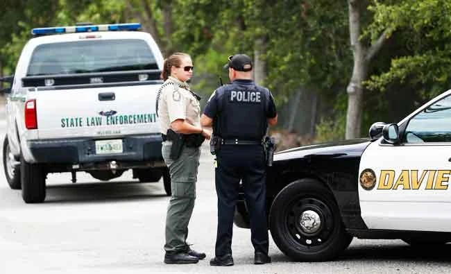 Law enforcement officers gather at the entrance of Silver Lakes Rotary Nature Park, Friday, June 8, 2018, in Davie, Fla. (AP)