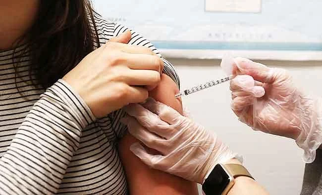 This file photo taken on January 21, 2018 shows a young woman as she receives a flu shot at a Walgreens pharmacy in San Francisco, California. (AFP)