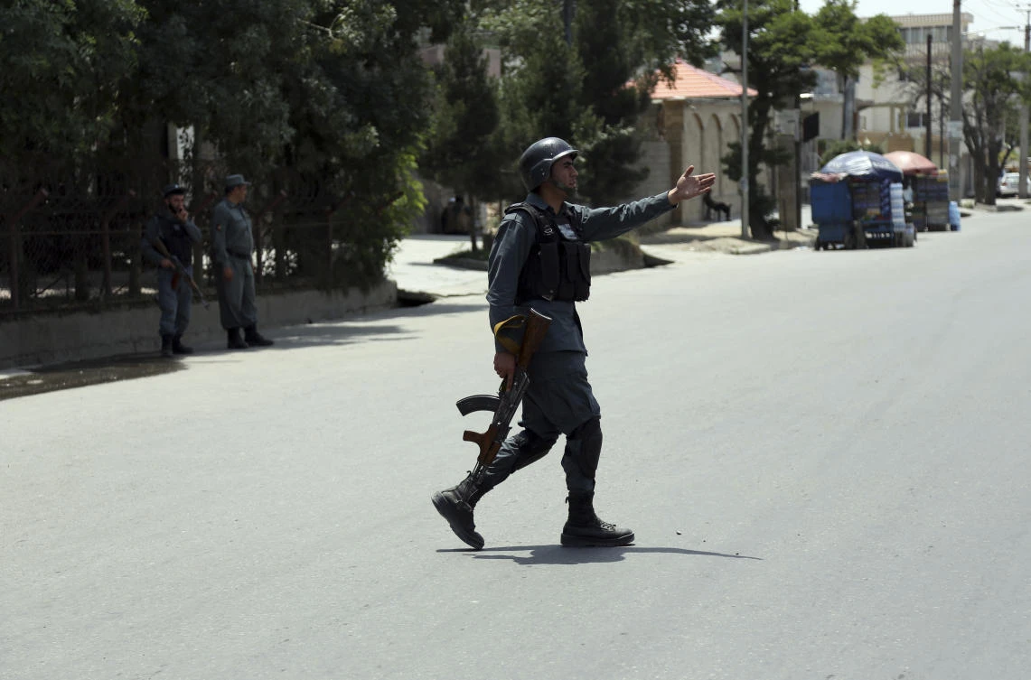 A member of Afghan security personnel gestures at the site of suicide attack in Kabul, Afghanistan. (AP)