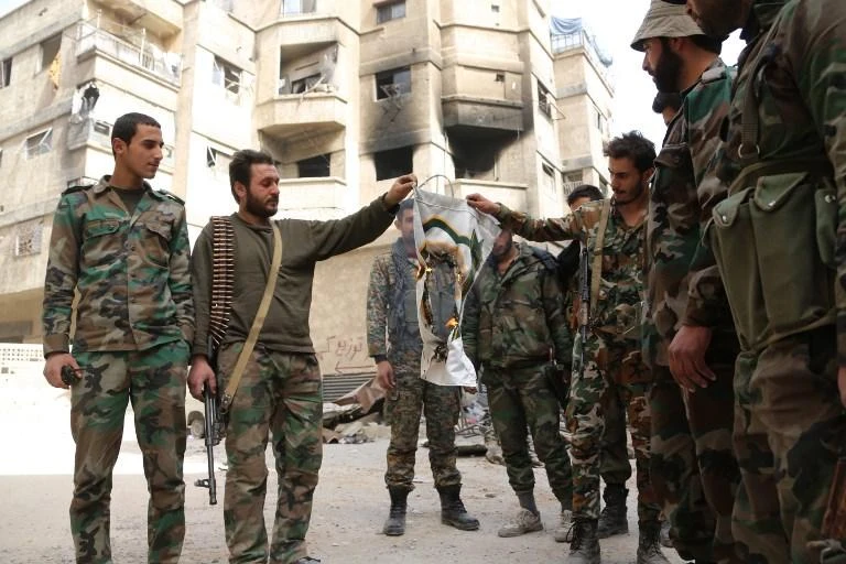 Syrian pro-government fighters can be seen wearing their official uniforms in the town of Hazzeh in Eastern Ghouta, on the outskirts of the Syrian capital Damascus, on March 27, 2018. (AFP)