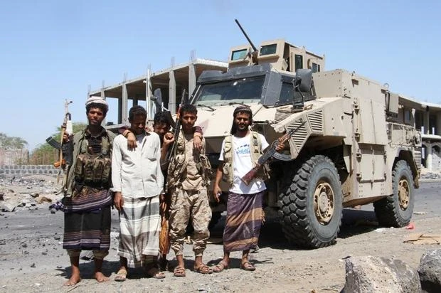 File photo showing fighters loyal to the Saudi-backed Yemeni government pose in front of an armored vehicle in the western Yemeni coastal town of Mokha. (AFP)