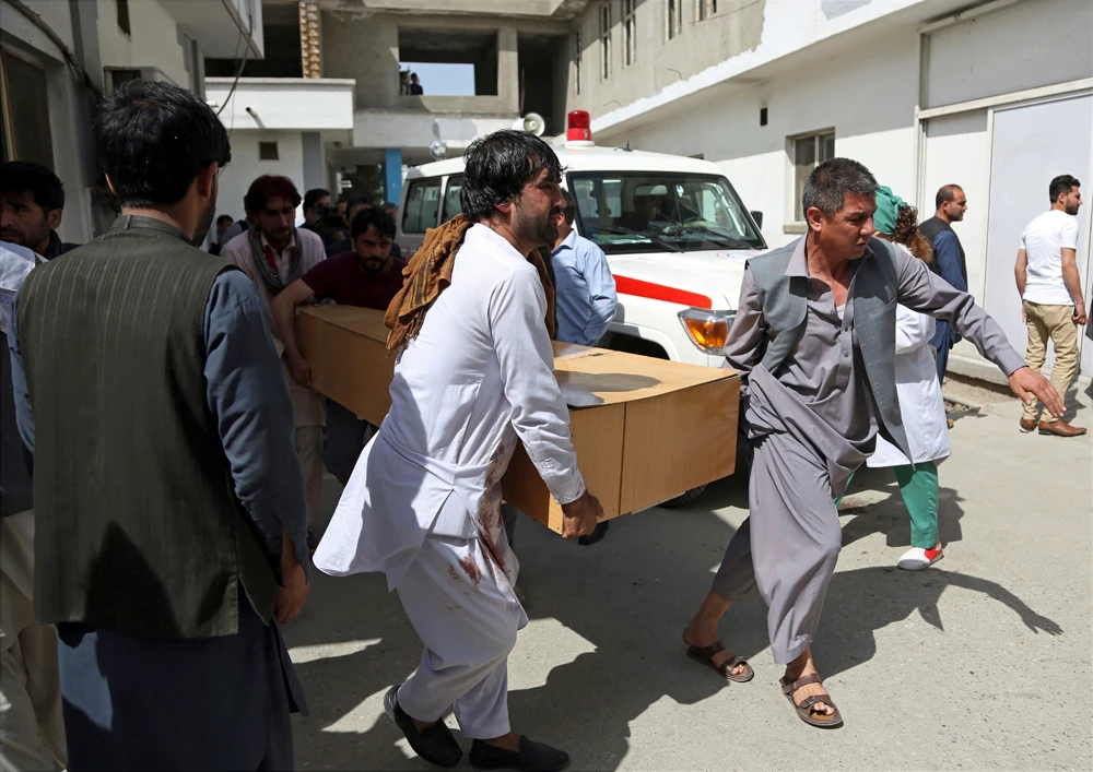 Relatives stand over a victim at a hospital after a suicide attack in Kabul on June 11, 2018. (Mohammad Ismail/Reuters)