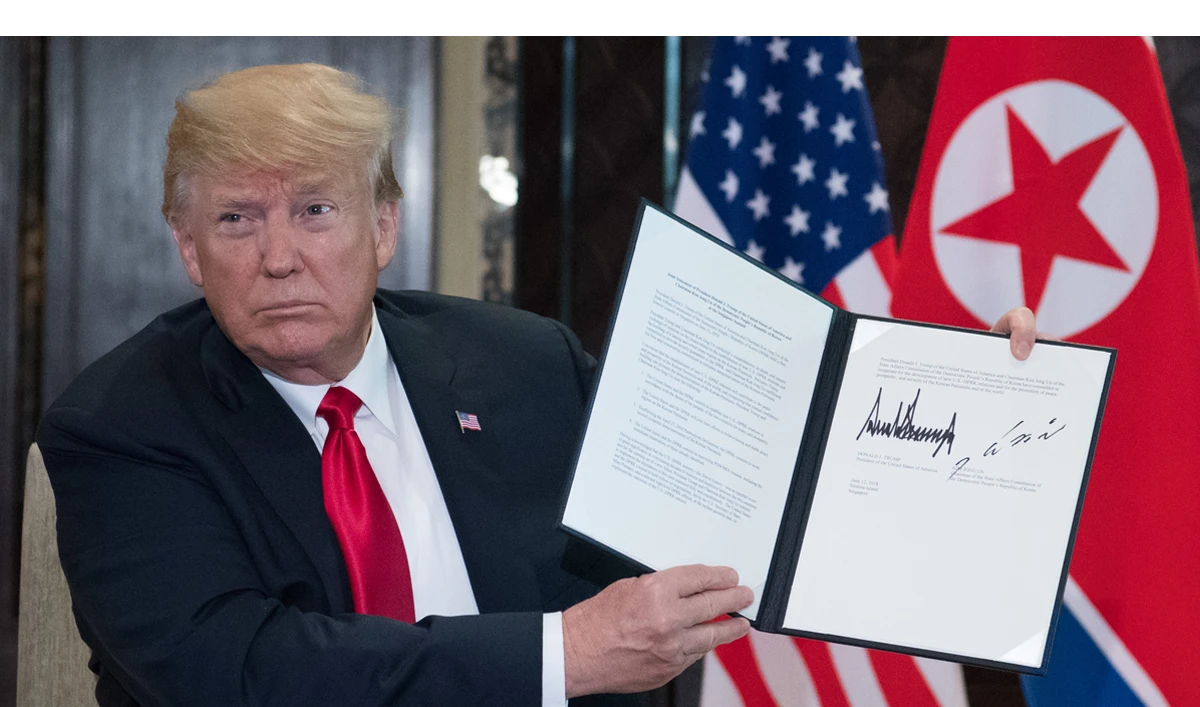 US President Donald Trump holds up a document signed by him and North Korea’s leader Kim Jong Un following a signing ceremony during their historic summit Singapore on Tuesday, June 12. (AFP)