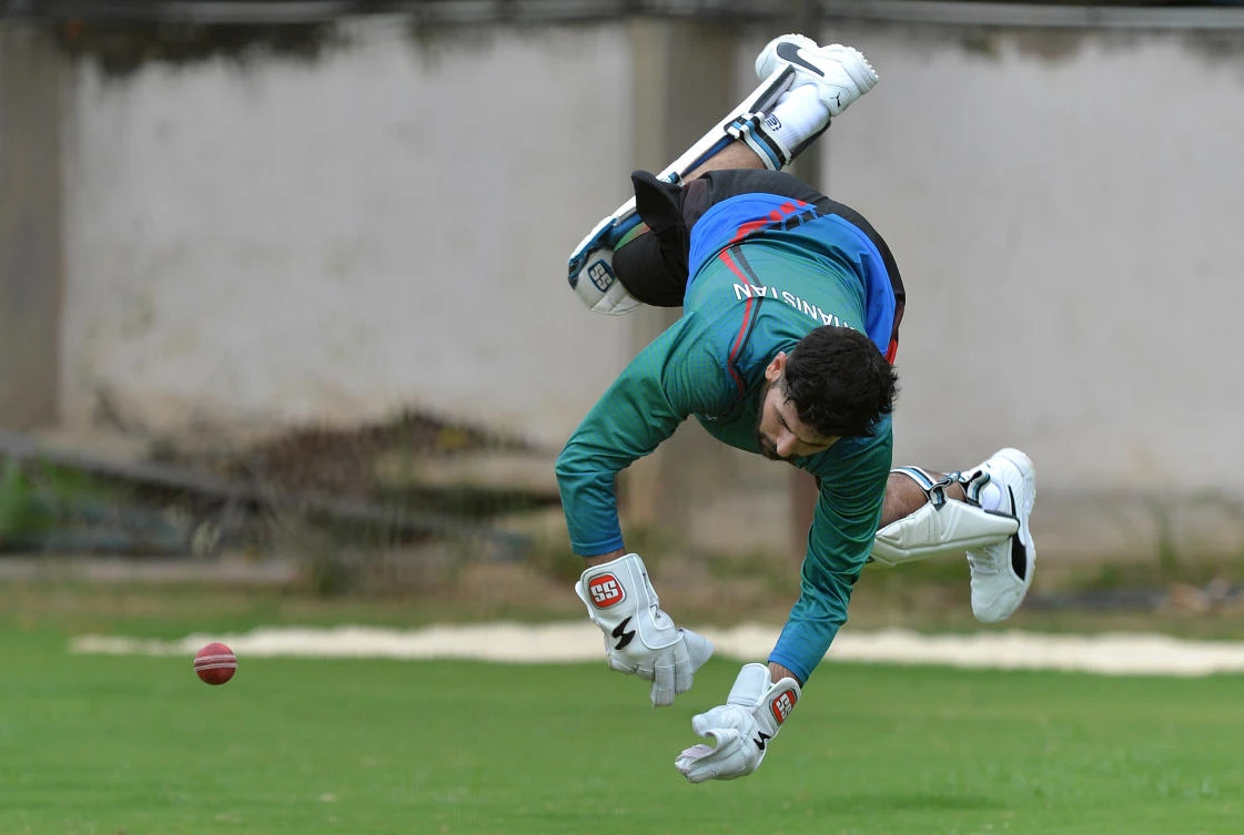 Afghanistan wicket keeper Afsar Zazai dives to stop a ball during a practice session at the M. Chinnaswamy Stadium in Bangalore. (AFP)