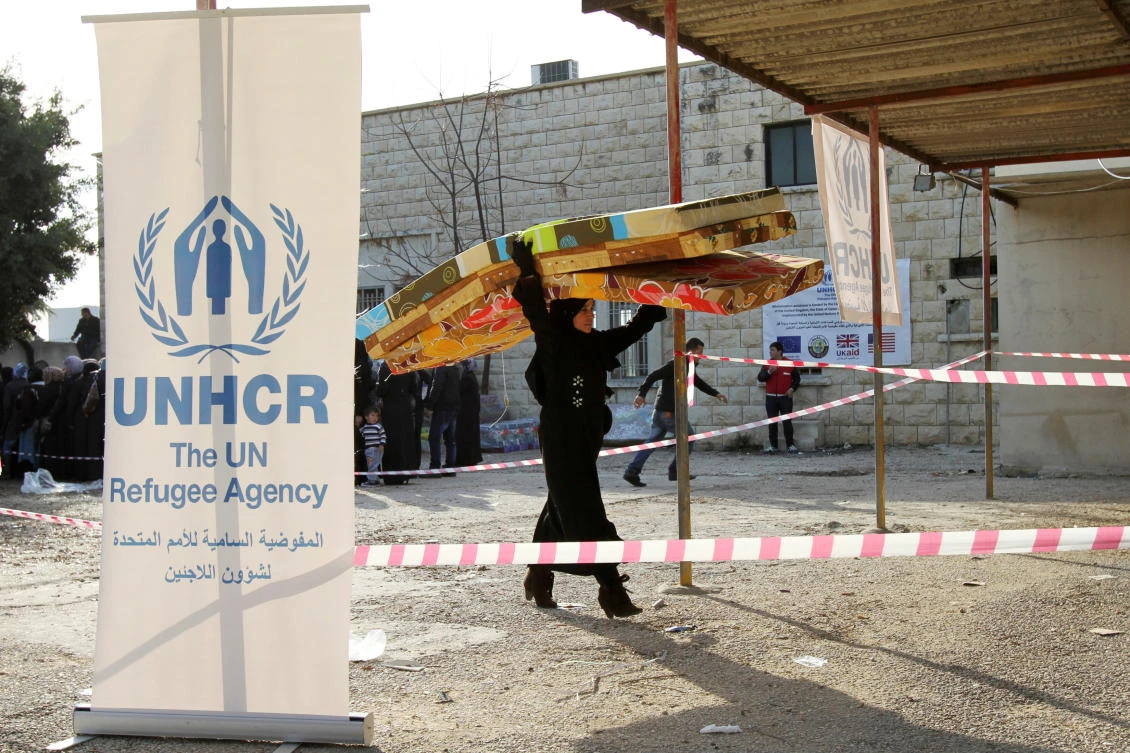 A Syrian refugee receives aid from the UN refugee agency (UNHCR) in Batroun, northern Lebanon January 13, 2015. (Reuters)