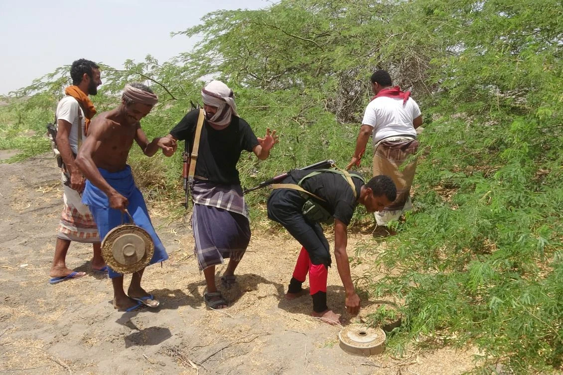 Photo showing Pro-government fighters carry explosives and land mines left behind by Iran backed Houthi militia near the city of AL-Jah, Hodeidah province, June 8, 2018. (AFP)