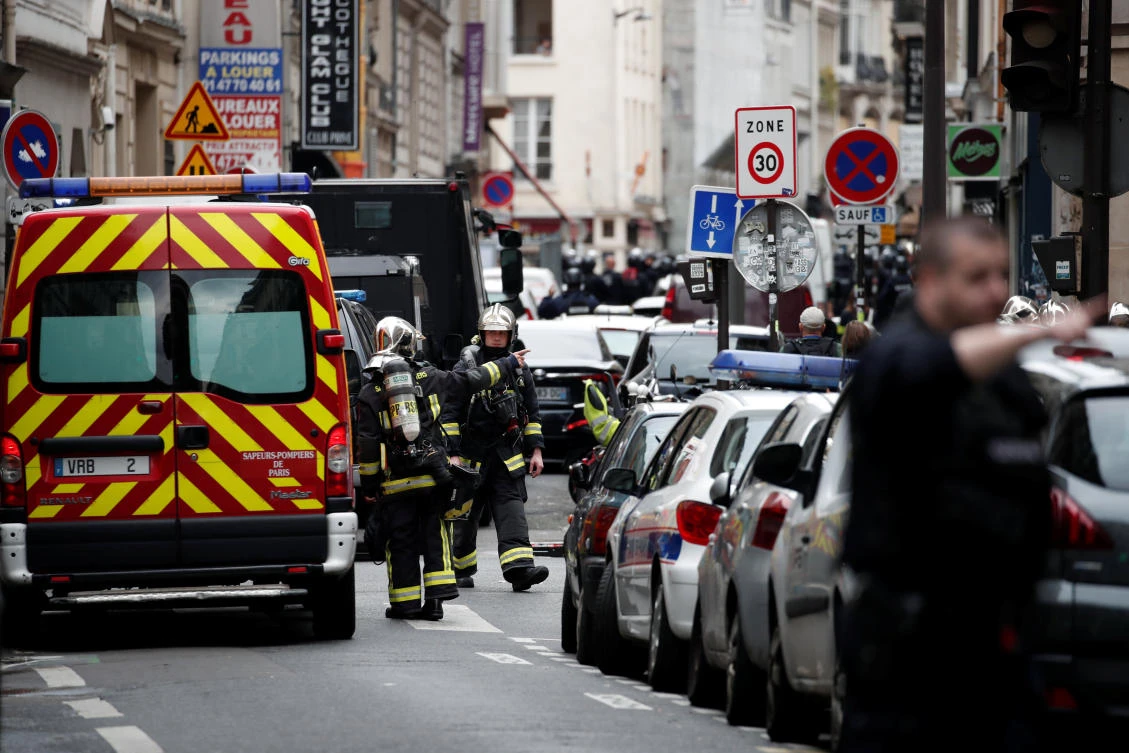 French police and firefighters secure the street as a man has taken two people hostage at a business in Paris, France, June 12, 2018. (Reuters)