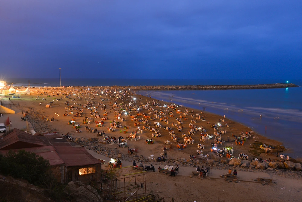 Moroccans break Ramadan fast on beach with song, dance, food