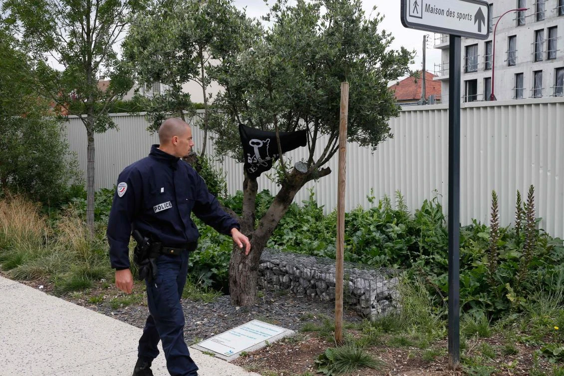 A policeman walks past a plaque near an olive tree from which a banner hangs showing a ‘key’ and the word ‘return’ written in Arabic in Bezons. The mayor of Bezons, a city in the suburbs of Paris, subsequently withdrew the plaque installed to commemorate Nakba, or “catastrophe,” when more than 760,000 Palestinians were expelled by Israeli forces or fled 70 years ago. (AFP)
