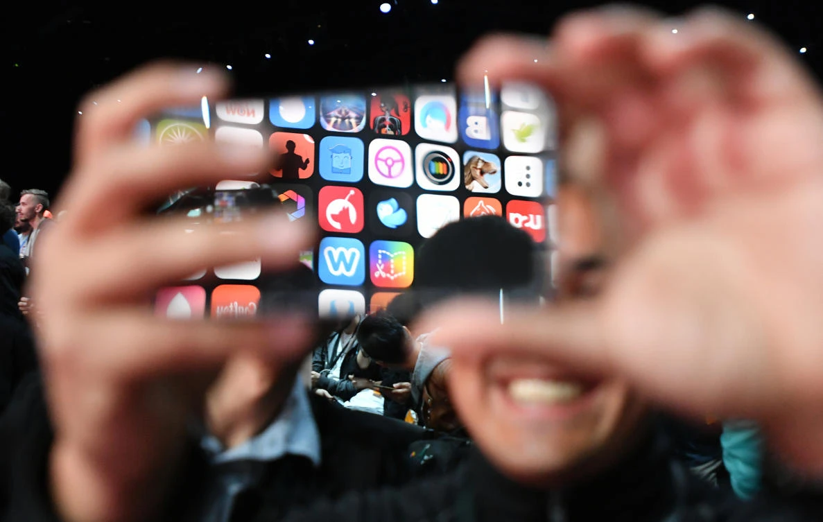 Apple said the new features are not designed to frustrate law enforcement but prevent any bypassing of encryption by good or bad actors. Above, a visitor uses his iPhone X to take photos at the Apple Worldwide Developer conference in San Jose, California. (AFP)