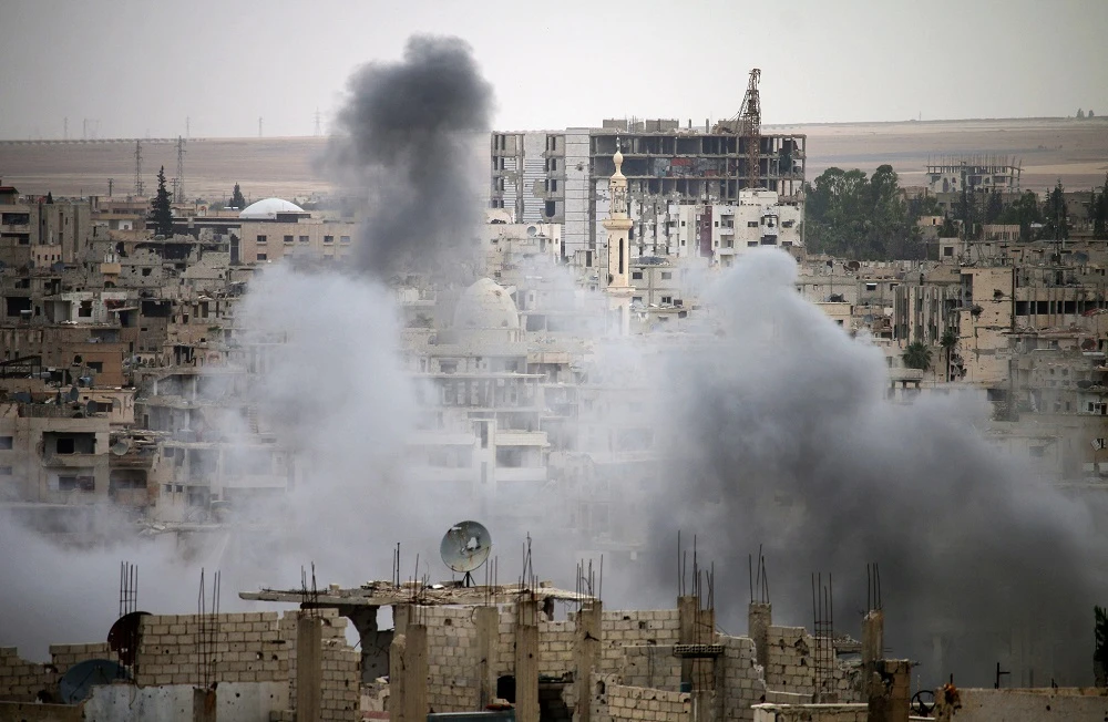 Smoke rises from buildings in a rebel-held neighbourhood of Daraa in southern Syria following reported shelling by the regime on May 22, 2018. (AFP)