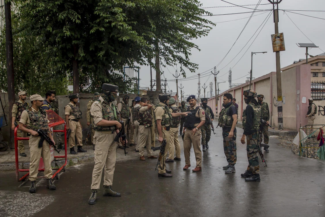 Indian policemen and paramilitary soldiers stand guard near the site of shootout in Srinagar, Indian controlled Kashmir, Friday, June 15, 2018. (Dar Yasin/AP)