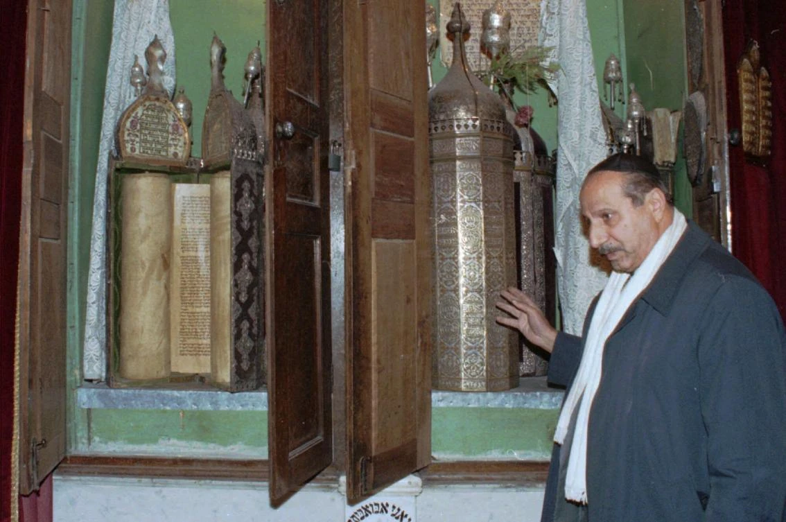 Youssef Jajati, a Jewish community leader in Syria, points out the Torah holy book preserved in a silver container in Joubar’s Synagogue which dates back to 718 BC. Artifacts removed from one of the oldest synagogues in the world have gone missing from the Syrian capital after neighborhood officials said they gave them to commanders of a rebel group who never returned them. (AP/Bassem Tellawi, File)