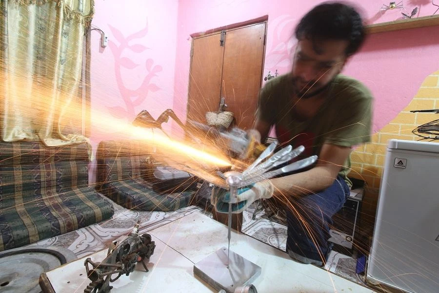Iraqi Omar Abdallah operates at his workshop in Basra on June 17, 2018. (AFP)