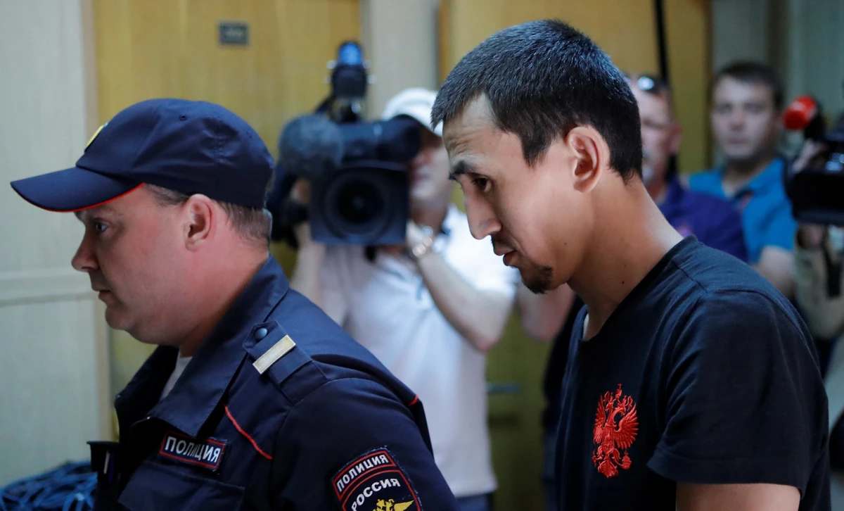 Anarbek Chingiz, the taxi driver who ploughed into crowd on June 16 in central Moscow, is escorted by police before a court hearing on his detention in Moscow, Russia June 18, 2018. (REUTERS/Sergei Karpukhin)