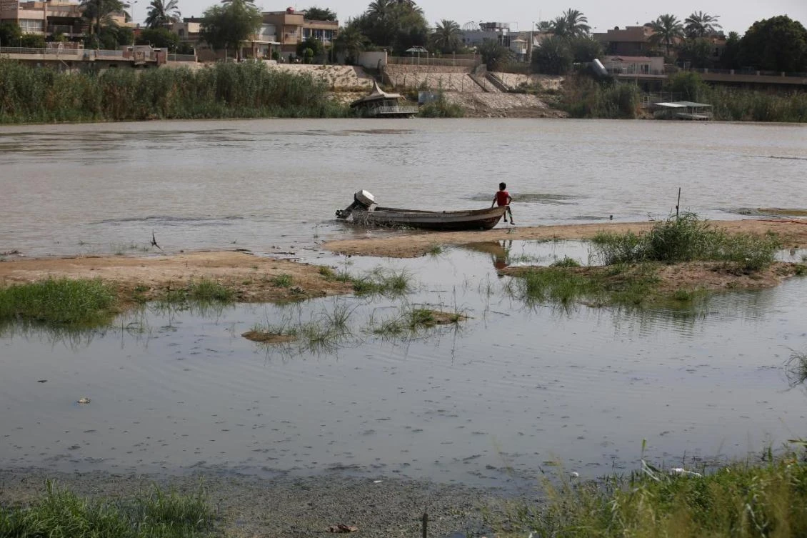 File photo showing a boy sits in a boat in Tigris River near Baghdad, Iraq, June 4, 2018. (Reuters)