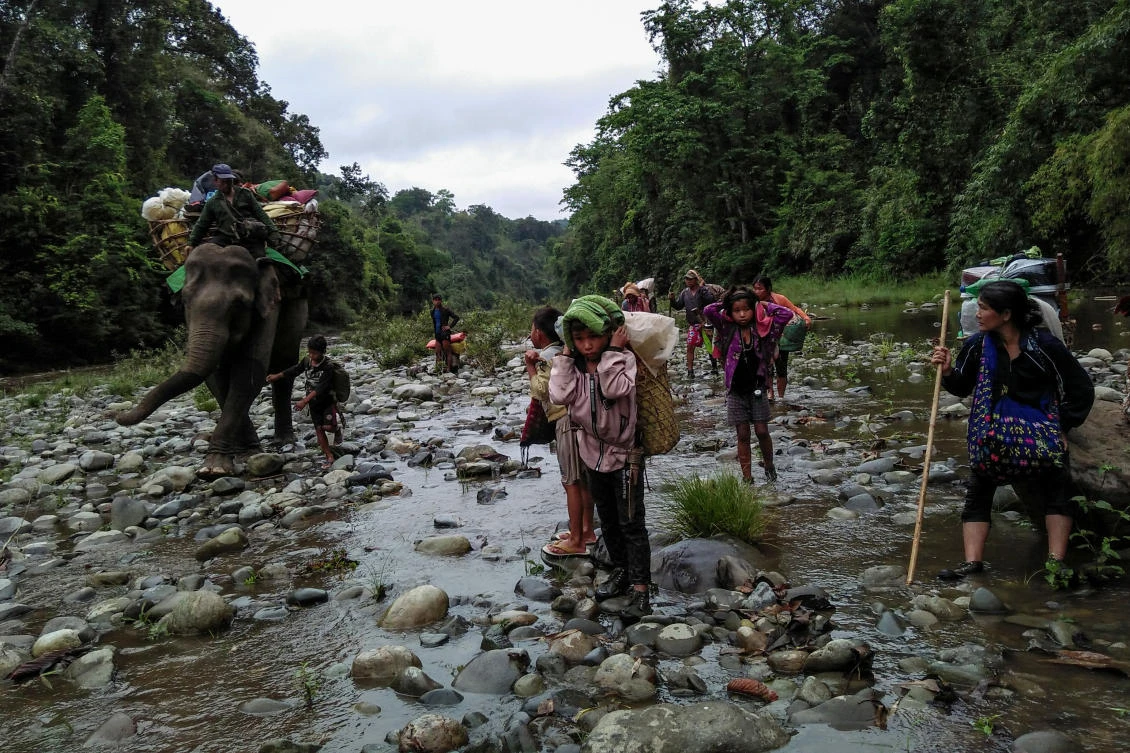 Internally displaced people ride an elephant as they make their way looking for a shelter in Danai, Myanmar. (AFP)