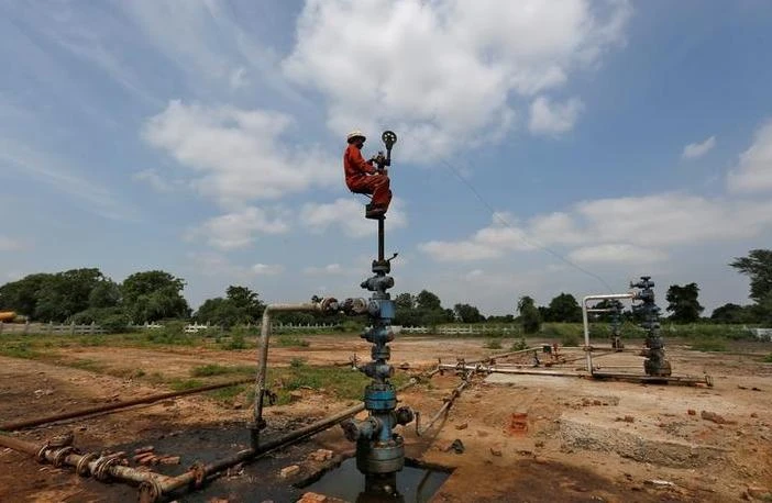 India is the world’s third-biggest oil consumer and importer. Above, a technician works at the Oil and Natural Gas Corp. wells at its oilfield on the outskirts of Ahmedabad in India. (Reuters)