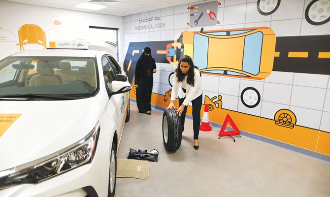 Trainee Maria Al-Faraj practices changing a tire during a driving lesson at the Saudi Aramco Driving Center in Dhahran. Reuters/File