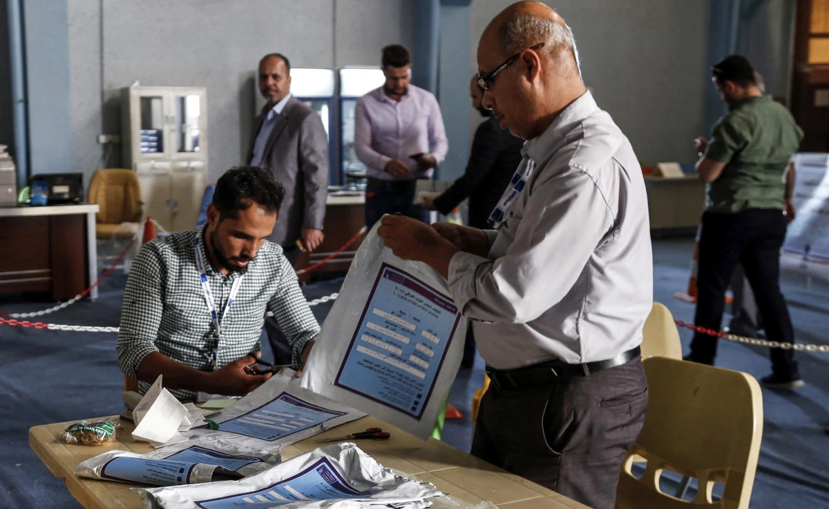 Electoral commission employees manually count ballots and compare them with electronic counting machine print-outs in Najaf on May 13. Iraq political uncertainty after the election, which was marred by a historically low turnout and allegations of fraud. (AFP)