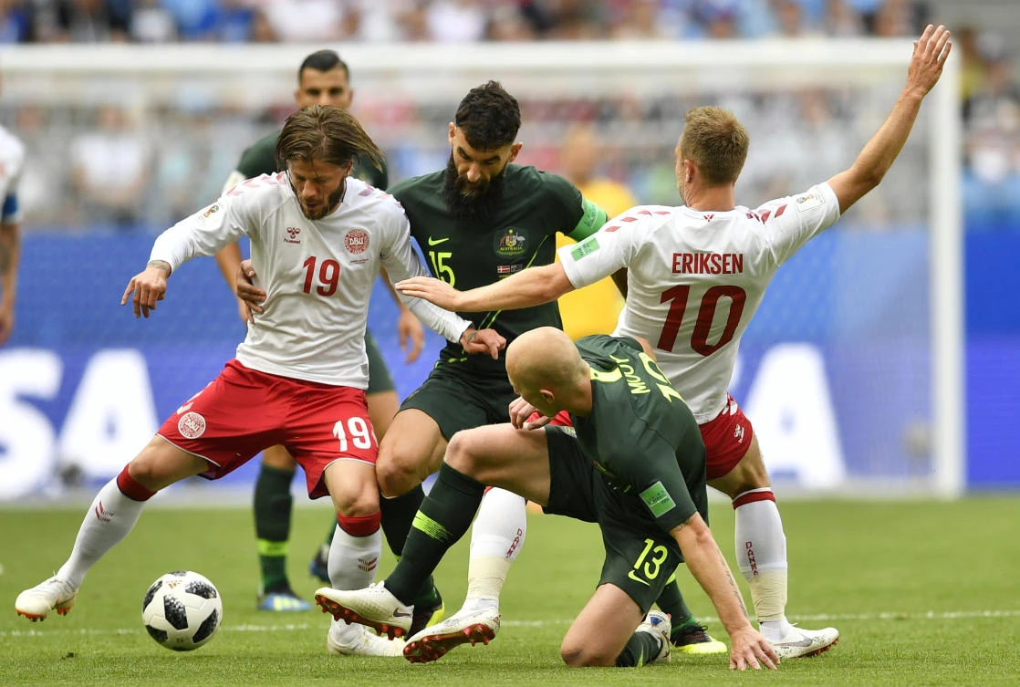 Denmark's Lasse Schone, left, and Christian Eriksen, right, are challenged by Australia's Mile Jedinak, center, and Aaron Mooy during the group C match between Denmark and Australia. (AP Photo/Martin Meissner)