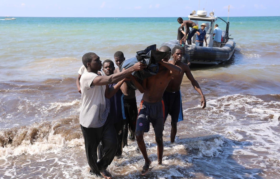 Photo showing rescuers carry a bag containing the dead body of a migrant, Tajoura, east of Tripoli, Libya June 20, 2018. (Reuters)